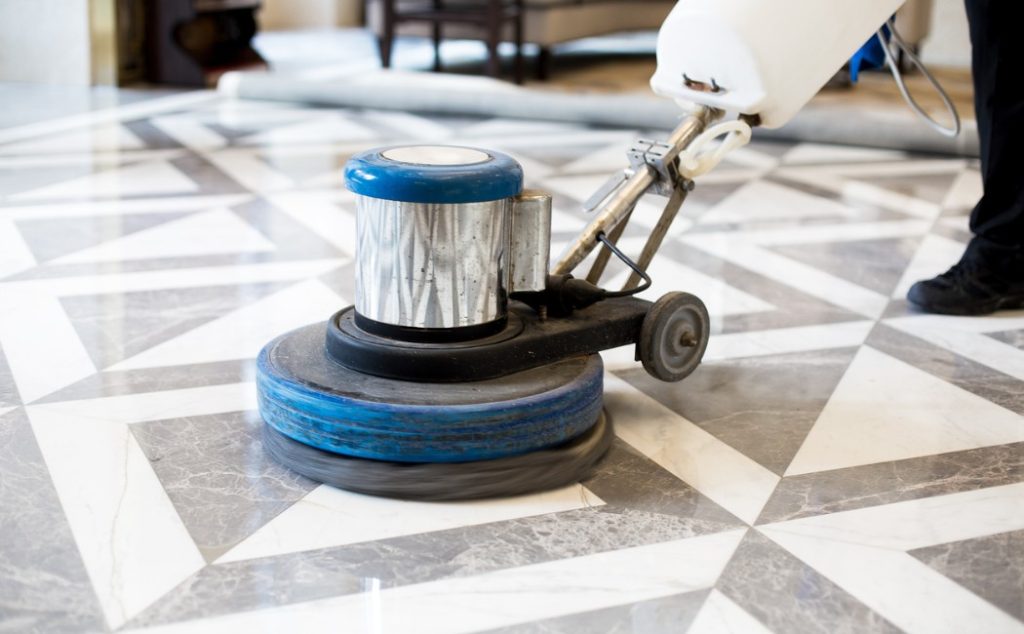 The image shows a floor polishing machine in action, providing professional floor polishing services for a clean, shiny surface.